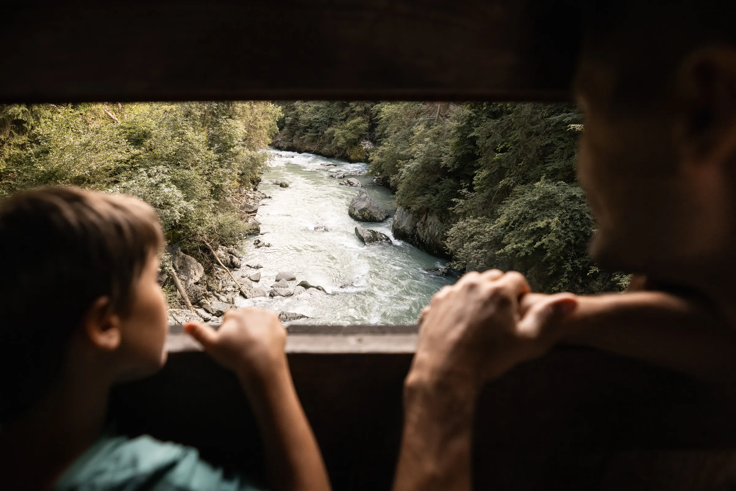Famiglia osserva un torrente di montagna in Alto Adige